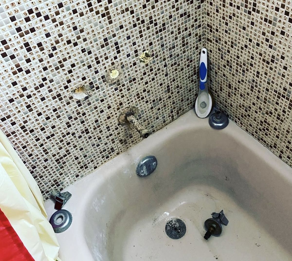 Before: tub and shower valve removed, with the old fixtures
